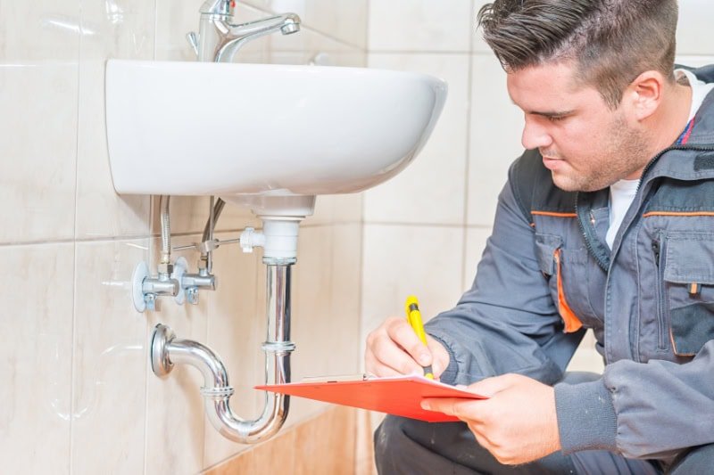 Do I Need a Plumbing Inspection? Plumber inspecting sink.